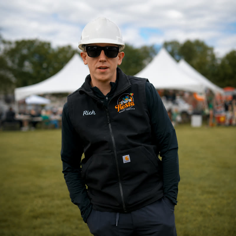 Pura Fiesta crew member in a hard hat ready to assemble rentals on site